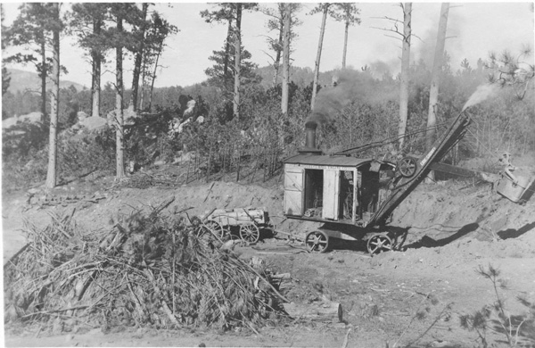 Old equipment clears trees to build a primitive road in rural america in the early 20th century
