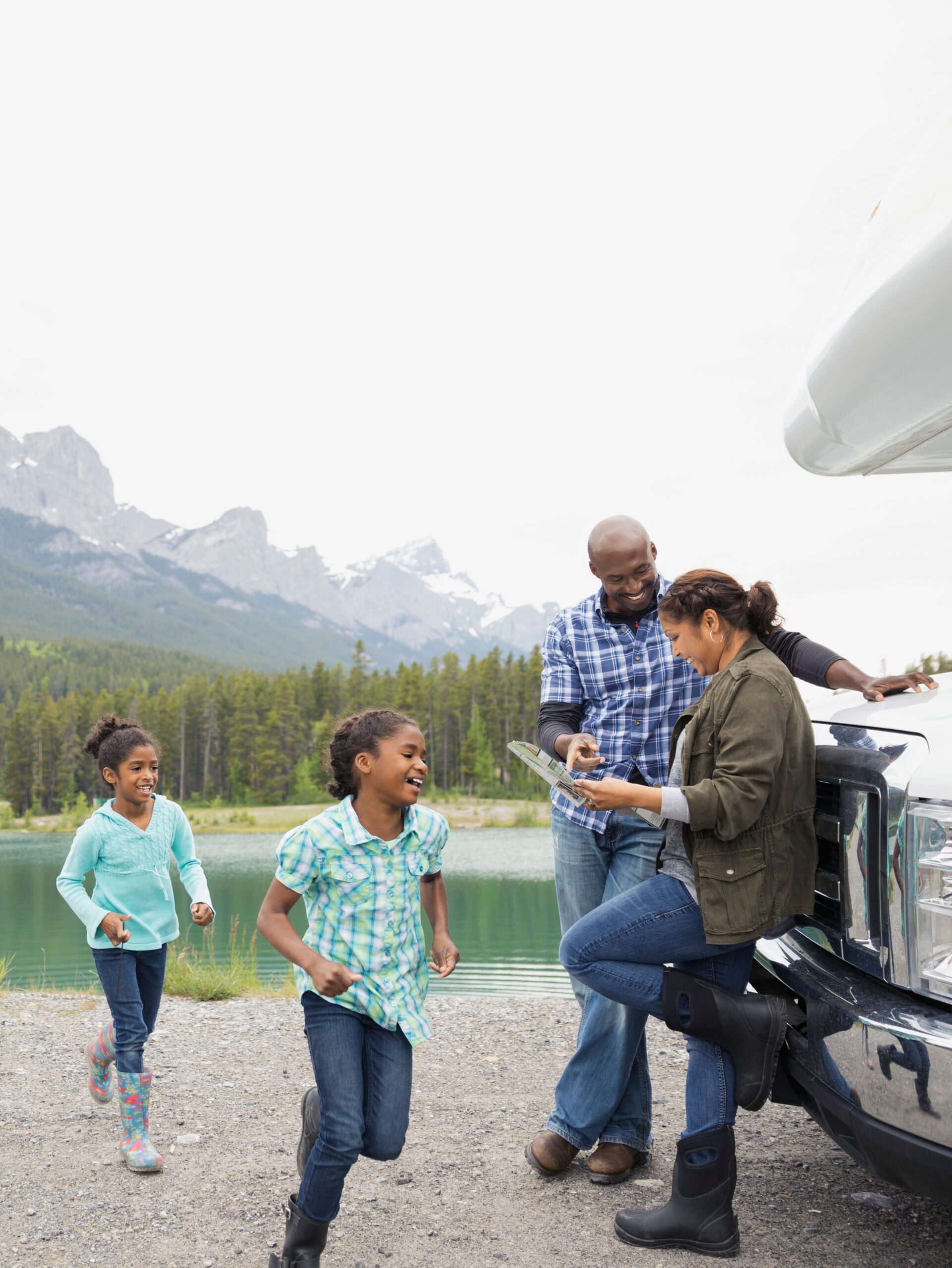 A young family studies American Road Trip History next to their RV in a U.S. National Park.